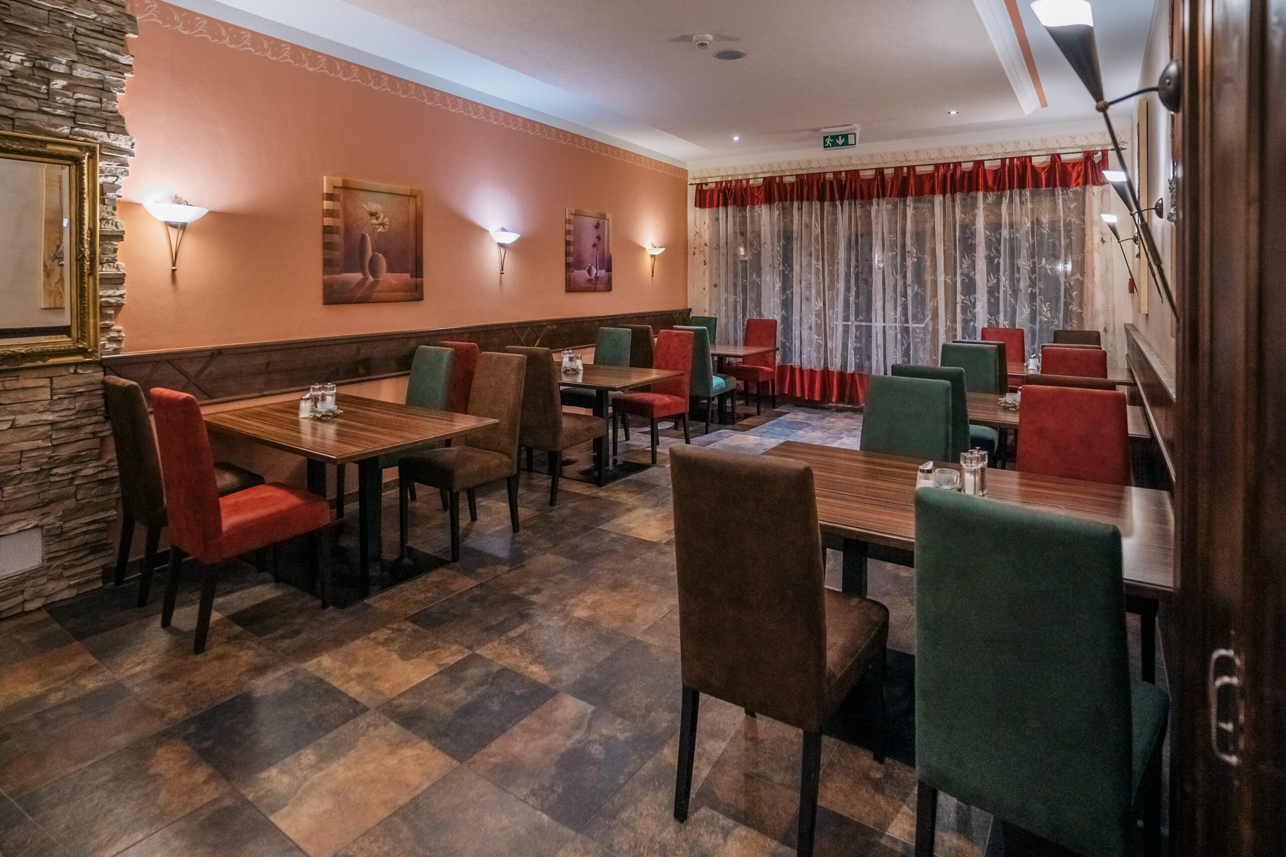 Das Hotel Austria Bistro mit modernen Holztischen und Stühlen in warmen Rottönen und einer entspannten, einladenden Atmosphäre