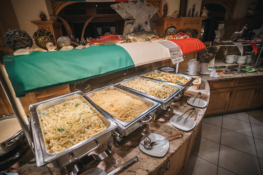Ein farbenfrohes Buffet mit italienischer Pasta, garniert mit frischen Kräutern und umrahmt von der italienischen Flagge