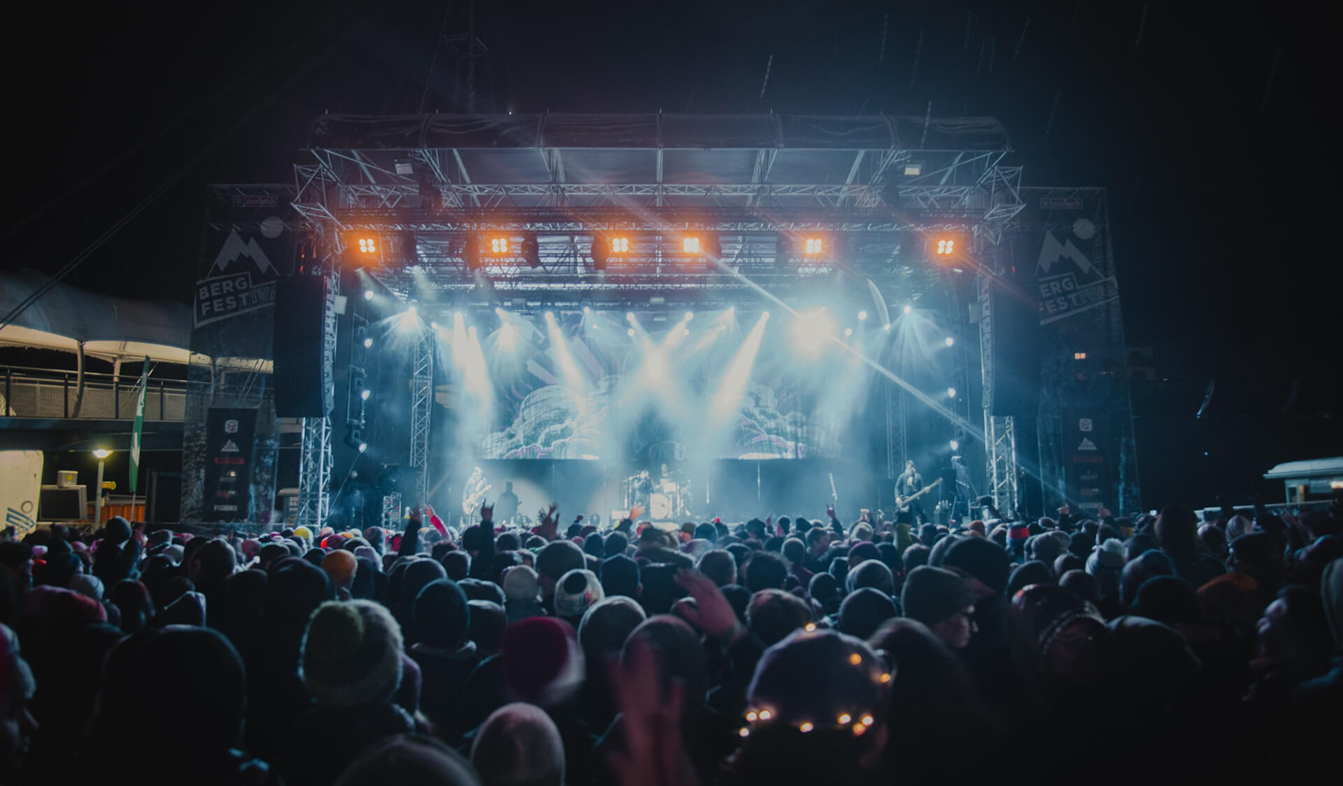 Besucher erleben ein nächtliches Konzert unter freiem Himmel mit dynamischer Bühnenbeleuchtung beim Bergfestival